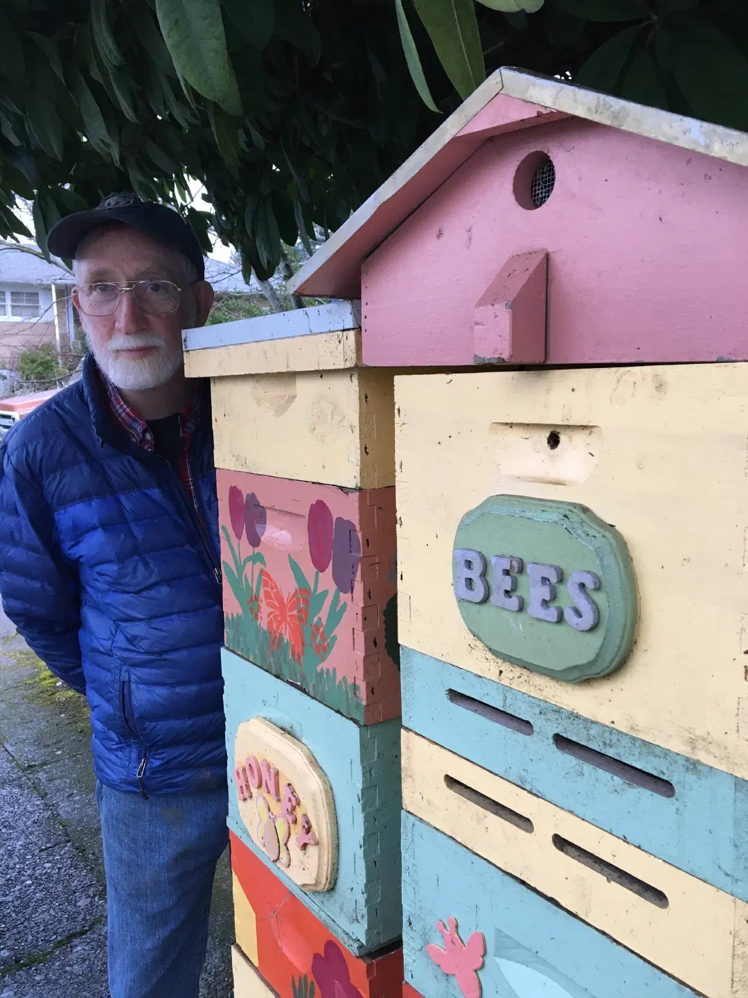Wes standing next to colorful beehives